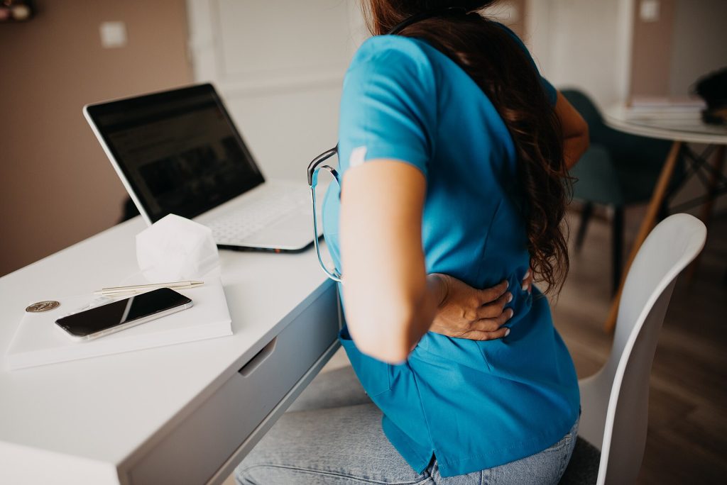 A person working on a laptop at home by a window